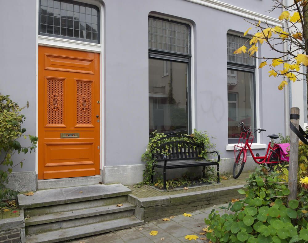 house with orange front door and red bicycle