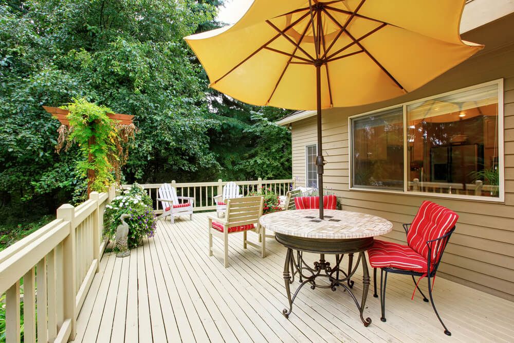 Wooden walkout deck with patio table, umbrella and chairs