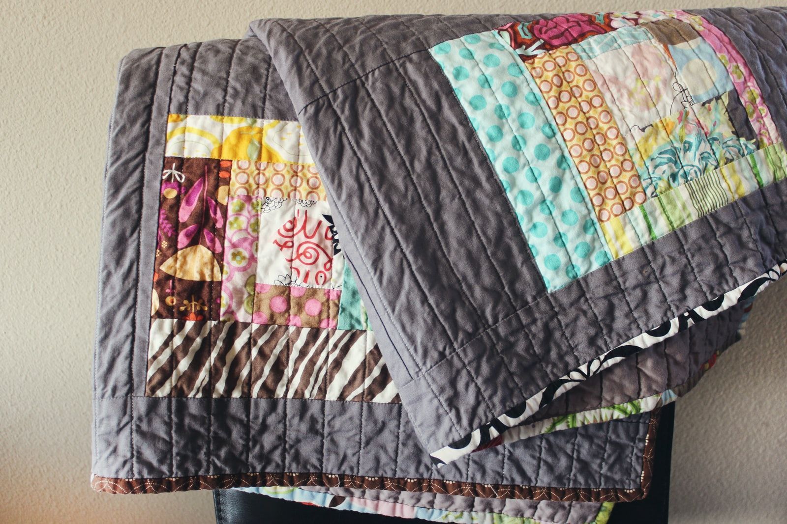 Housse de lit grise en patchwork avec motifs colorés