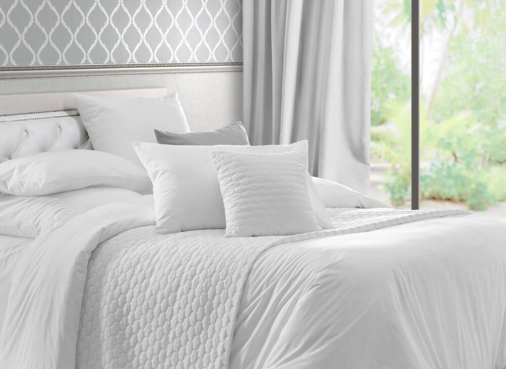 King bed with white linens and pillows.