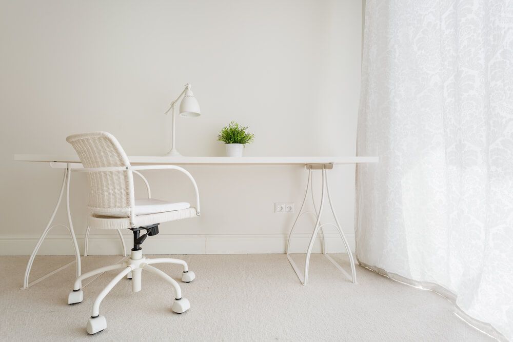 Simplistic study room in white with desk and chair