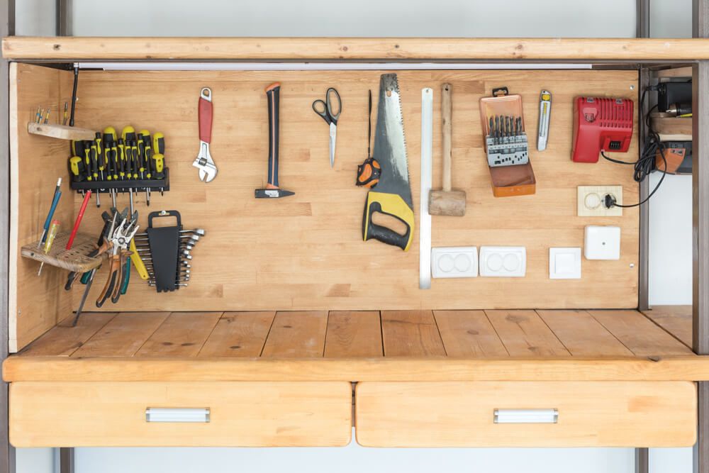 A wooden work bench with neatly organized tools and drawers