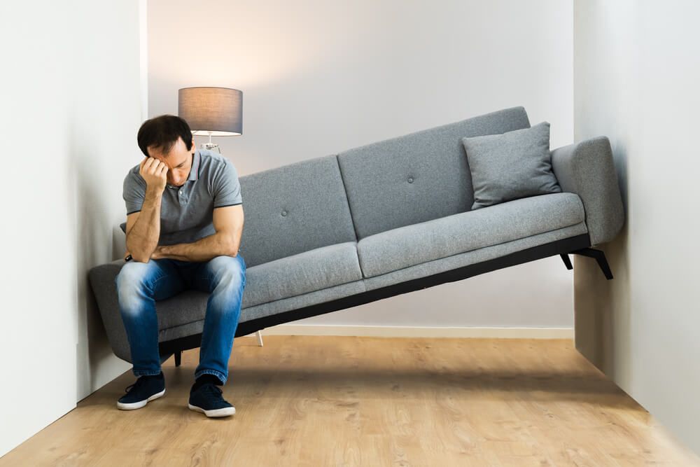 man stitting on a sofa that doesn't fit in his room