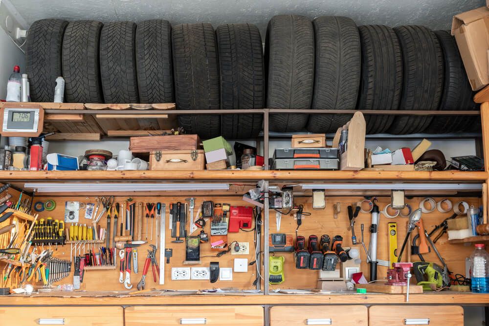 Garage work bench with several tires lined up above