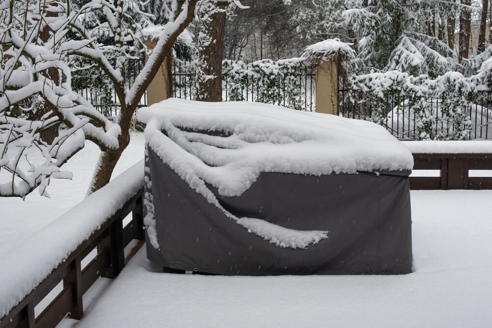 Patio furniture cover protecting outdoor furniture from snow.
