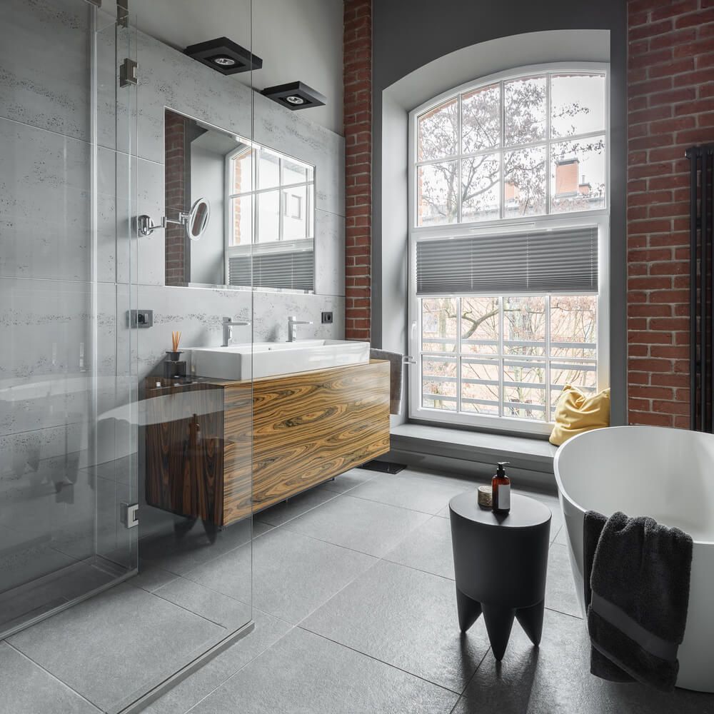 cuarto de baño de estilo industrial con pared de ladrillo y bañera