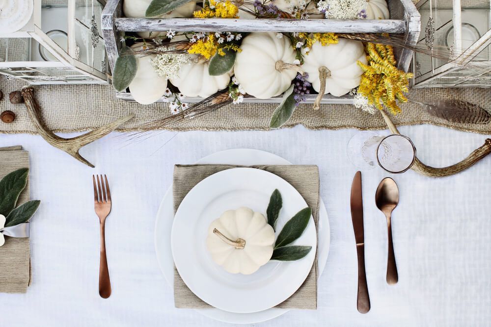 white themed table setting with bronze cutlery 