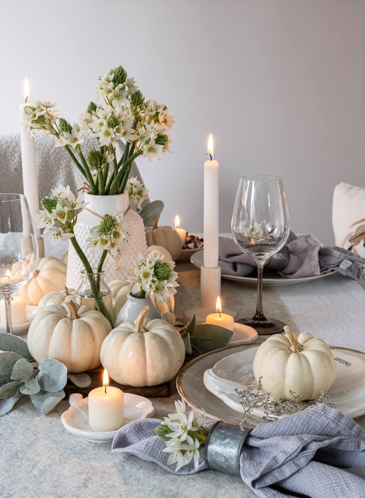 festive table setting with white pumpkins and silver table cloth
