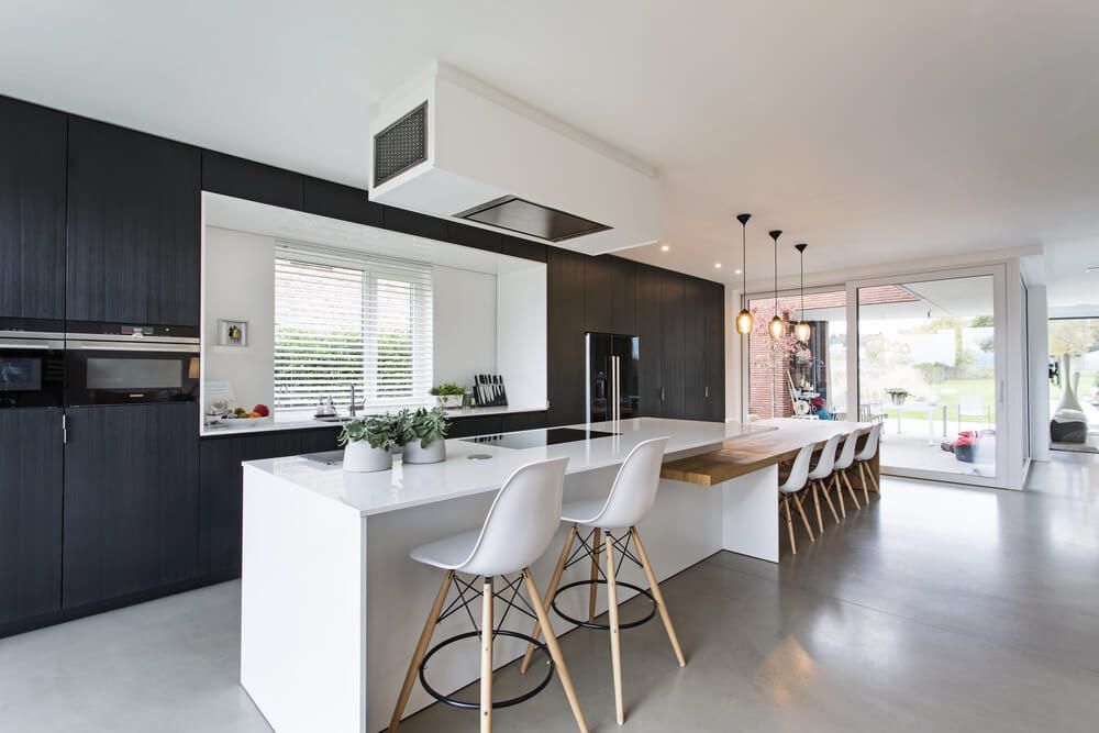 Black & white minimalistic kitchen with wood details. concrete floor, white island