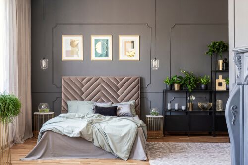 bedroom with grey walls, black cupboard, pictures on the wall, light green bedding