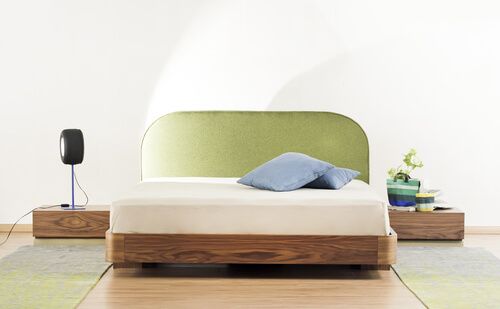 un grand lit en bois avec oreillers et deux tables de chevet en bois