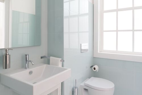 a light, clean bathroom corner with a toilet and a sink