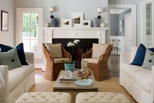 elegant living room with two rattan chairs, cream sofas, cushins of different color