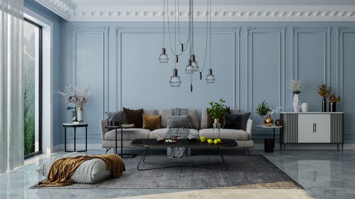 un salon bleu avec un canapé gris et de nombreux coussins, un tapis gris, un meuble de cuisine