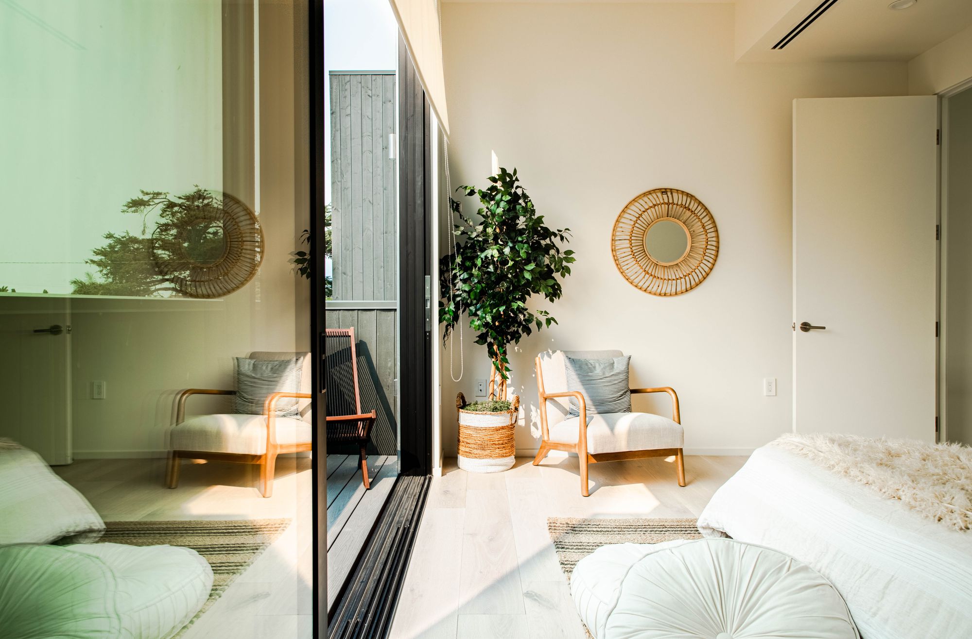 dormitorio grande y luminoso con ventanales, muebles de madera y colores claros, blanco