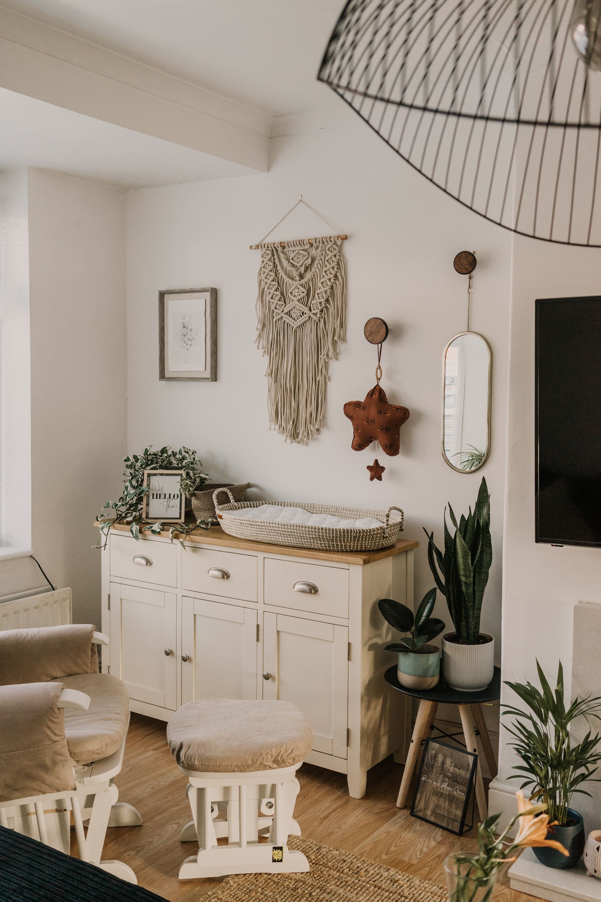 bonito dormitorio de bebé con tonos neutros y plantas, mueble cambiador blanco de madera