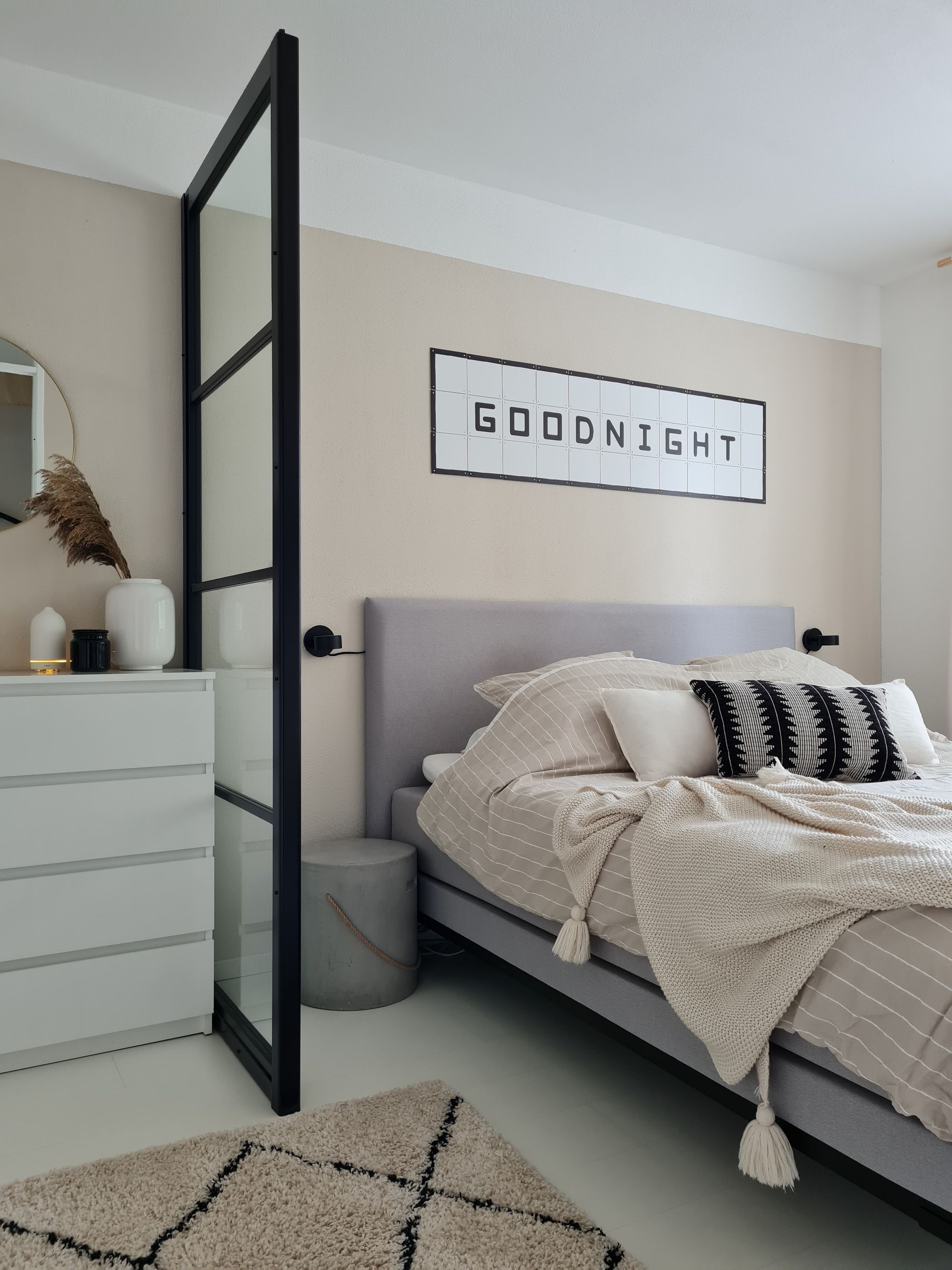Dormitorio juvenil con tonos neutros, cama con mantas beiges y cajonera blanca 