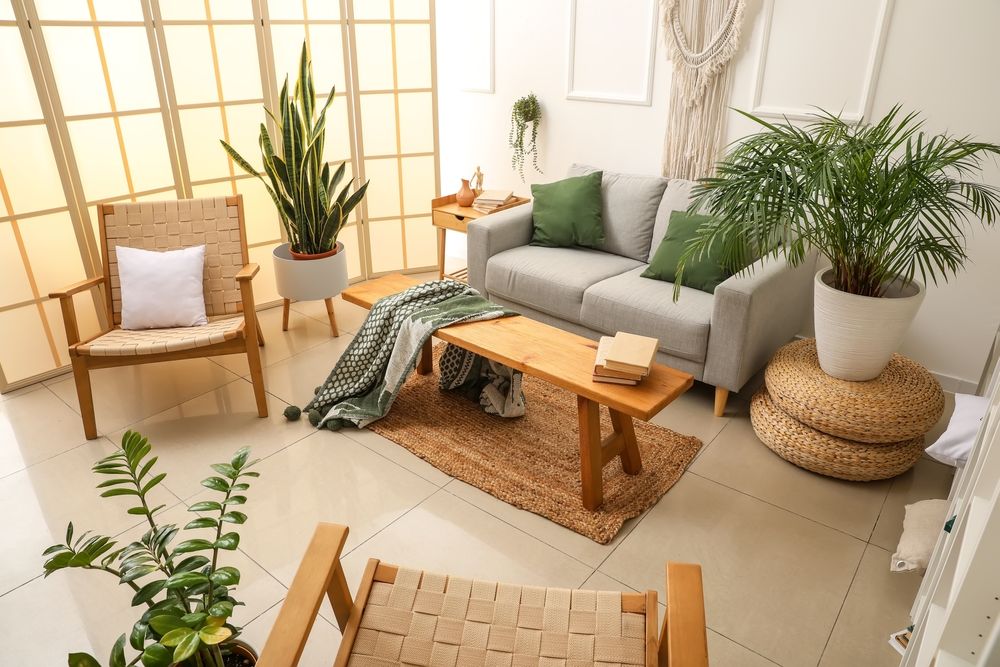 Wohnzimmerecke mit neutralen und grünen Farben, vielen Pflanzen und Holzmöbeln