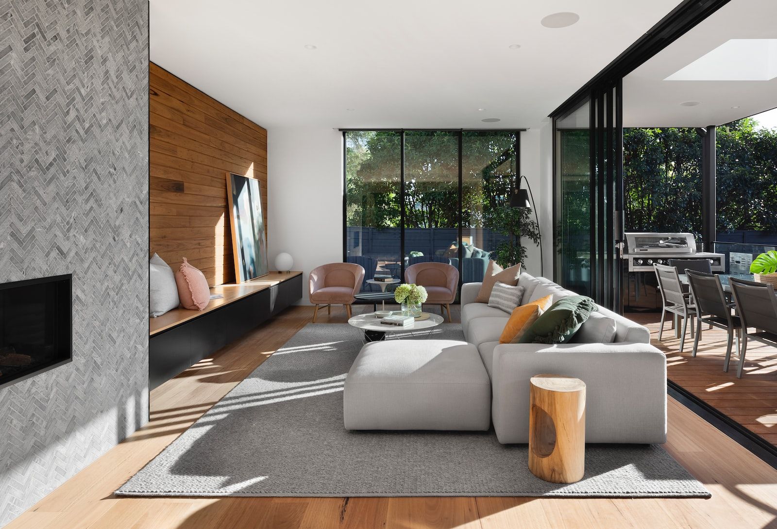 salon de style contemporain avec un canapé gris, des coussins et une salle à manger ouverte