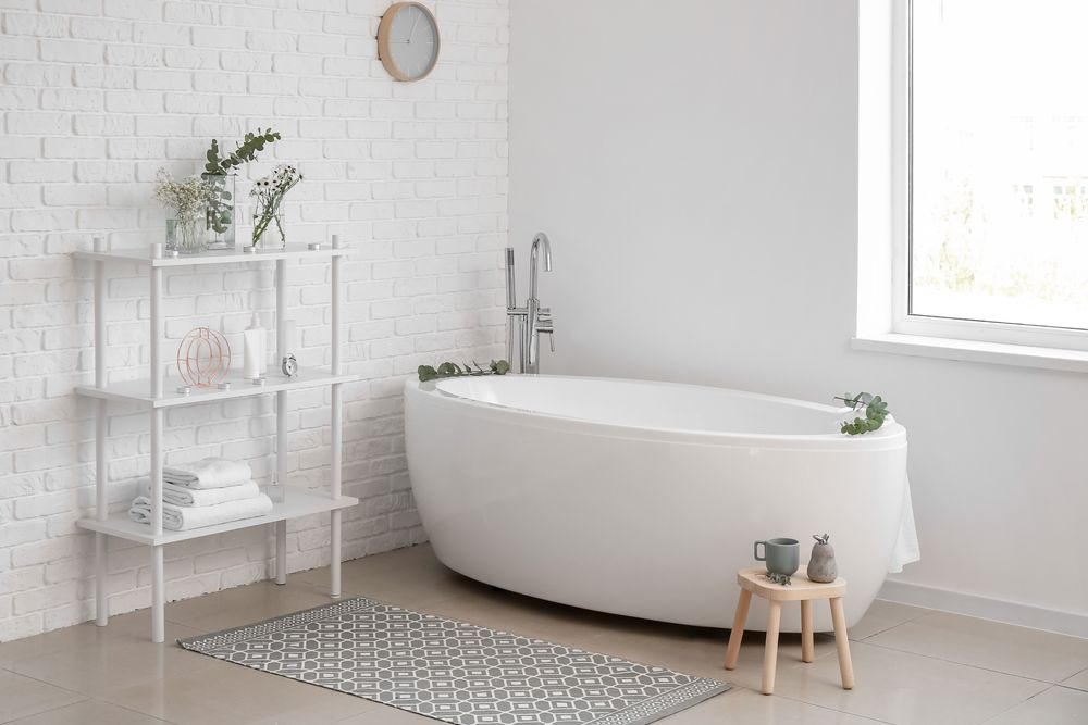white bathroom with freestanding tub and shelves