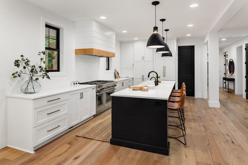 Open kitchen with black accents and mixed lighting sources