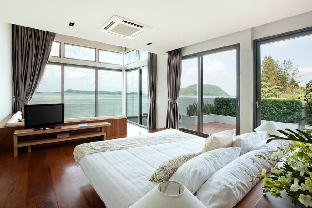 ein Hotelzimmer mit großen Glasfenstern mit Blick auf das Meer