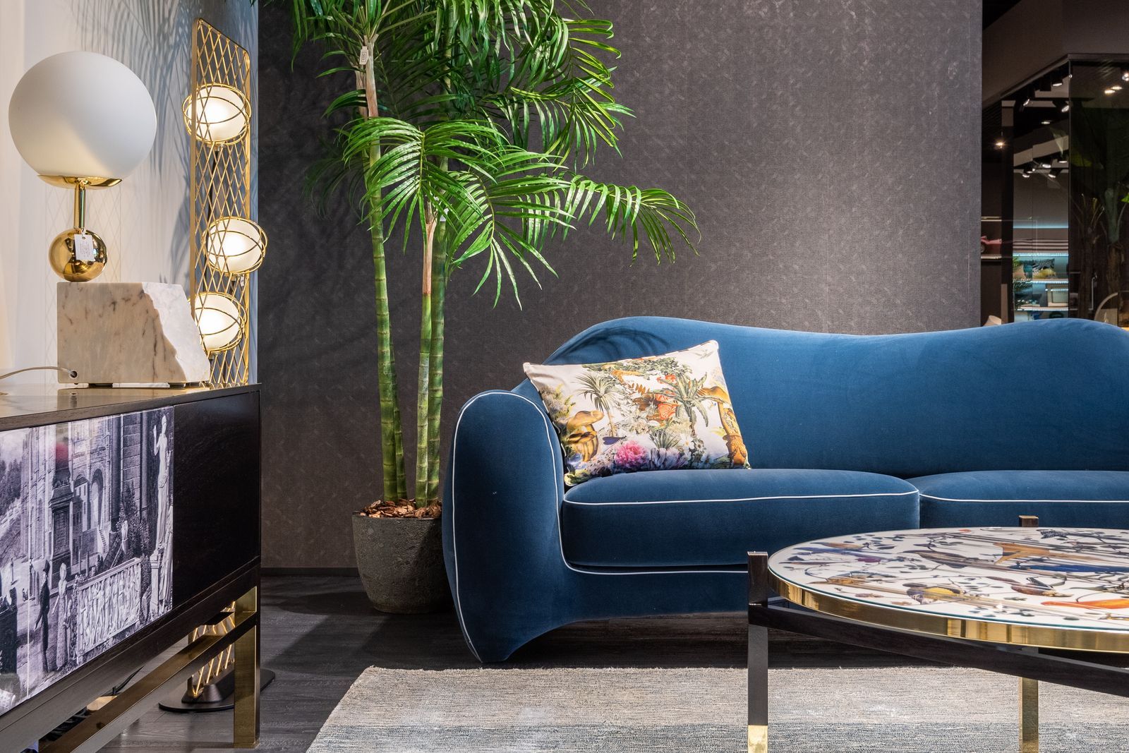 sala de estar decorada estilo glam con sofá azul y lámparas doradas