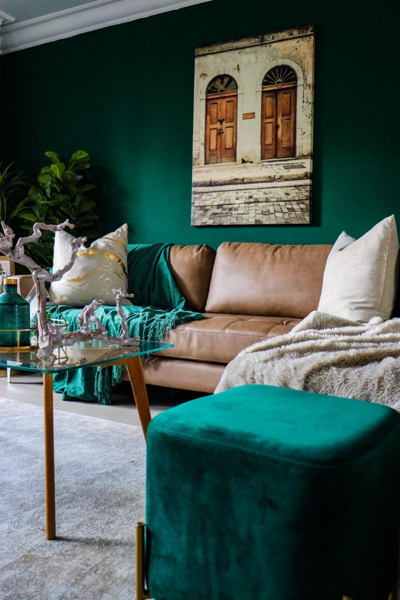 intérieur élégant avec des murs vert foncé, des accents bleus et un canapé marron