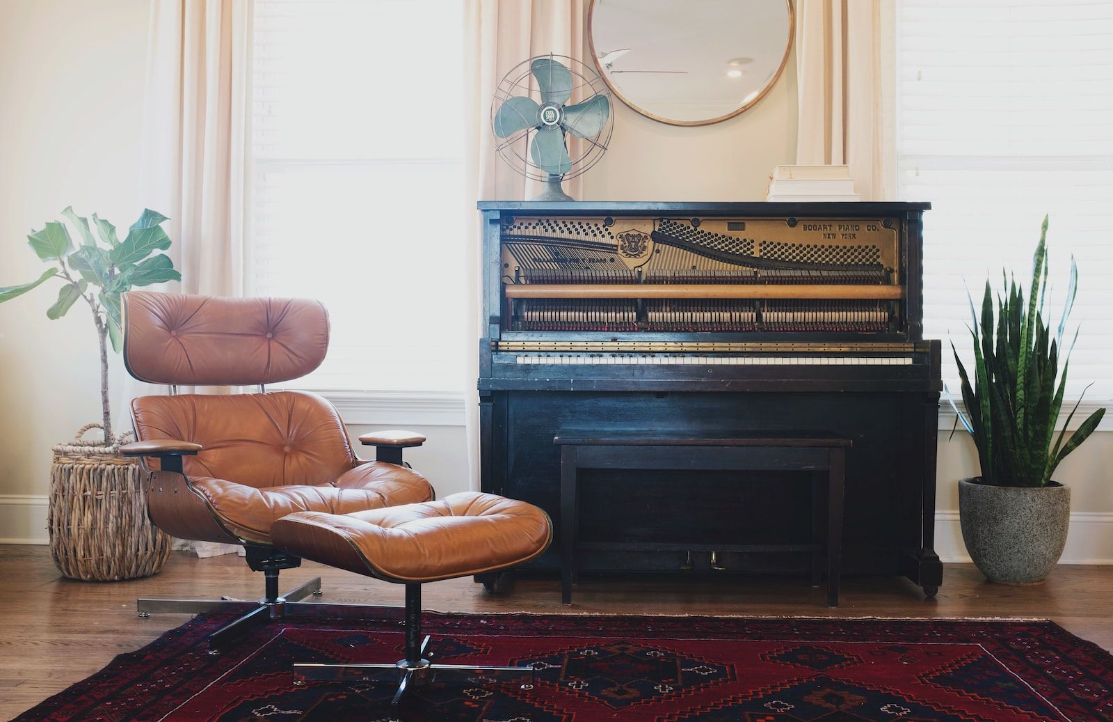 Salon clair et crème avec un vieux piano, un ventilateur et des plantes