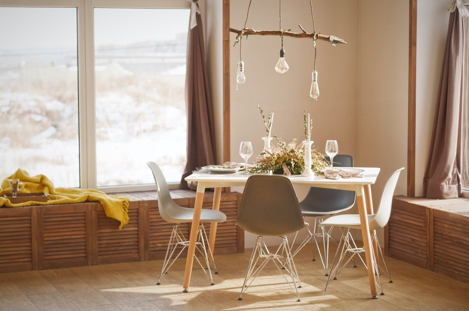 ein Esszimmer im skandinavischen Stil, ein Baumzweig hält 3 Lampenschirme