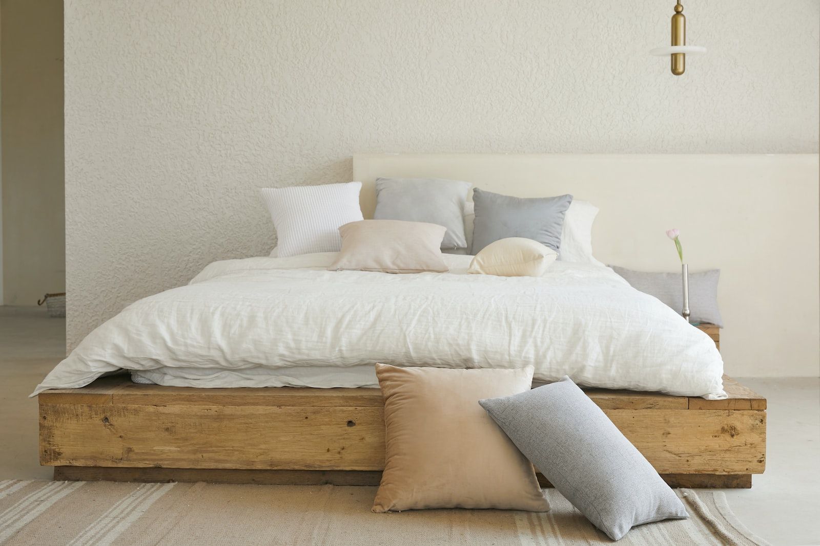 ein Holzbett mit weißer Bettwäsche