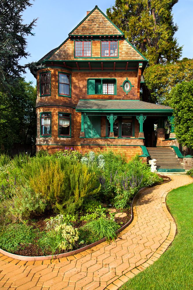 Victorian house with natural brown wood shingles and painted green trim