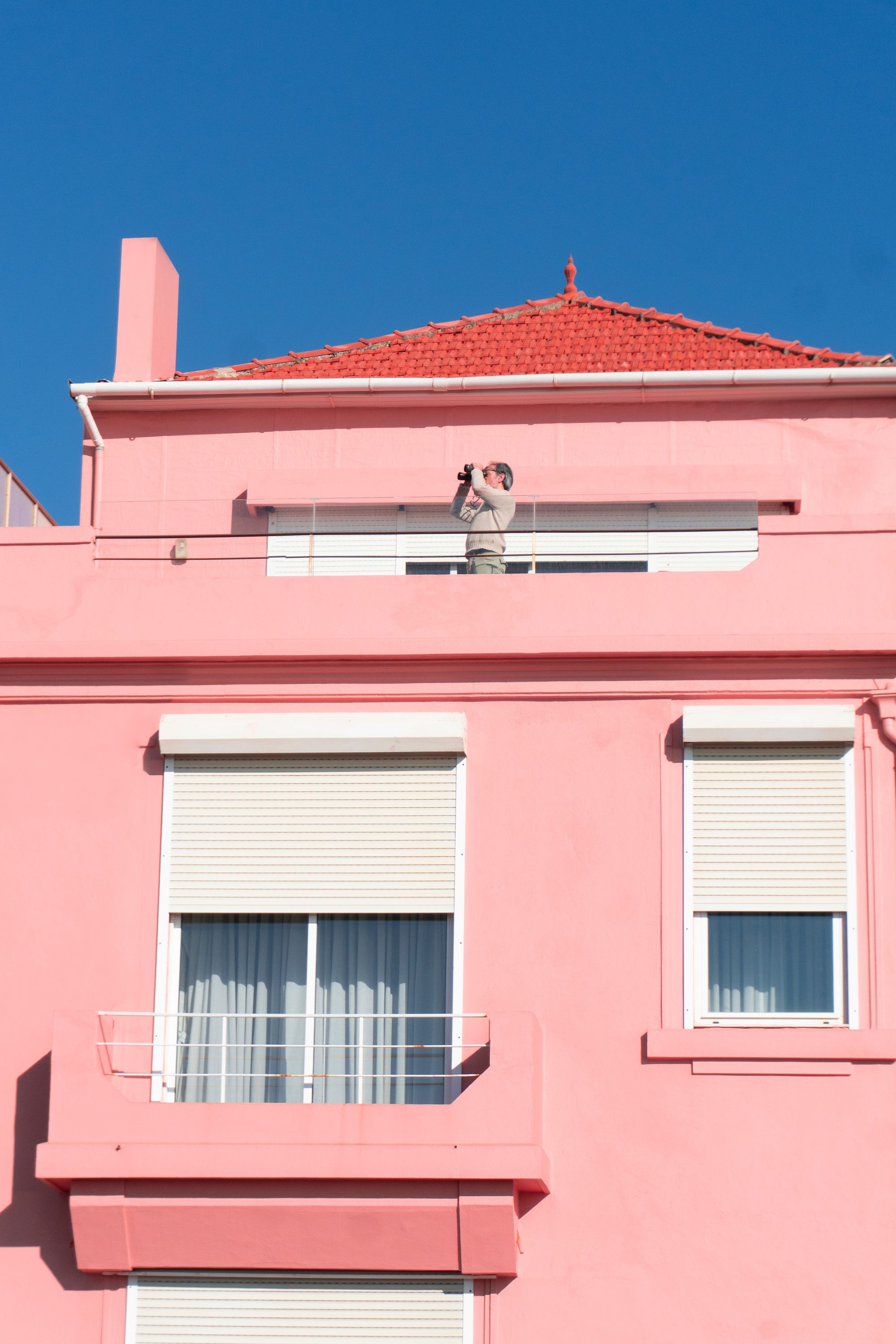 fachada rosa color barbie con ventanas blancas, casa barbiecore