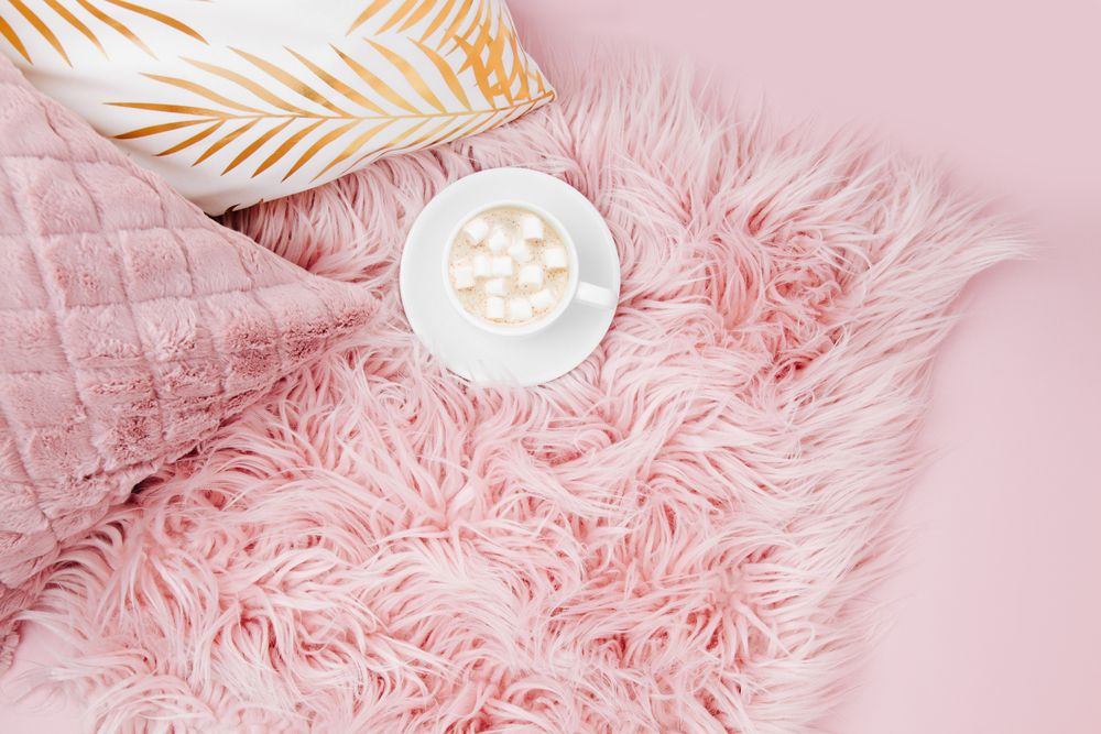 Stylish pink pillows and cup of coffee.