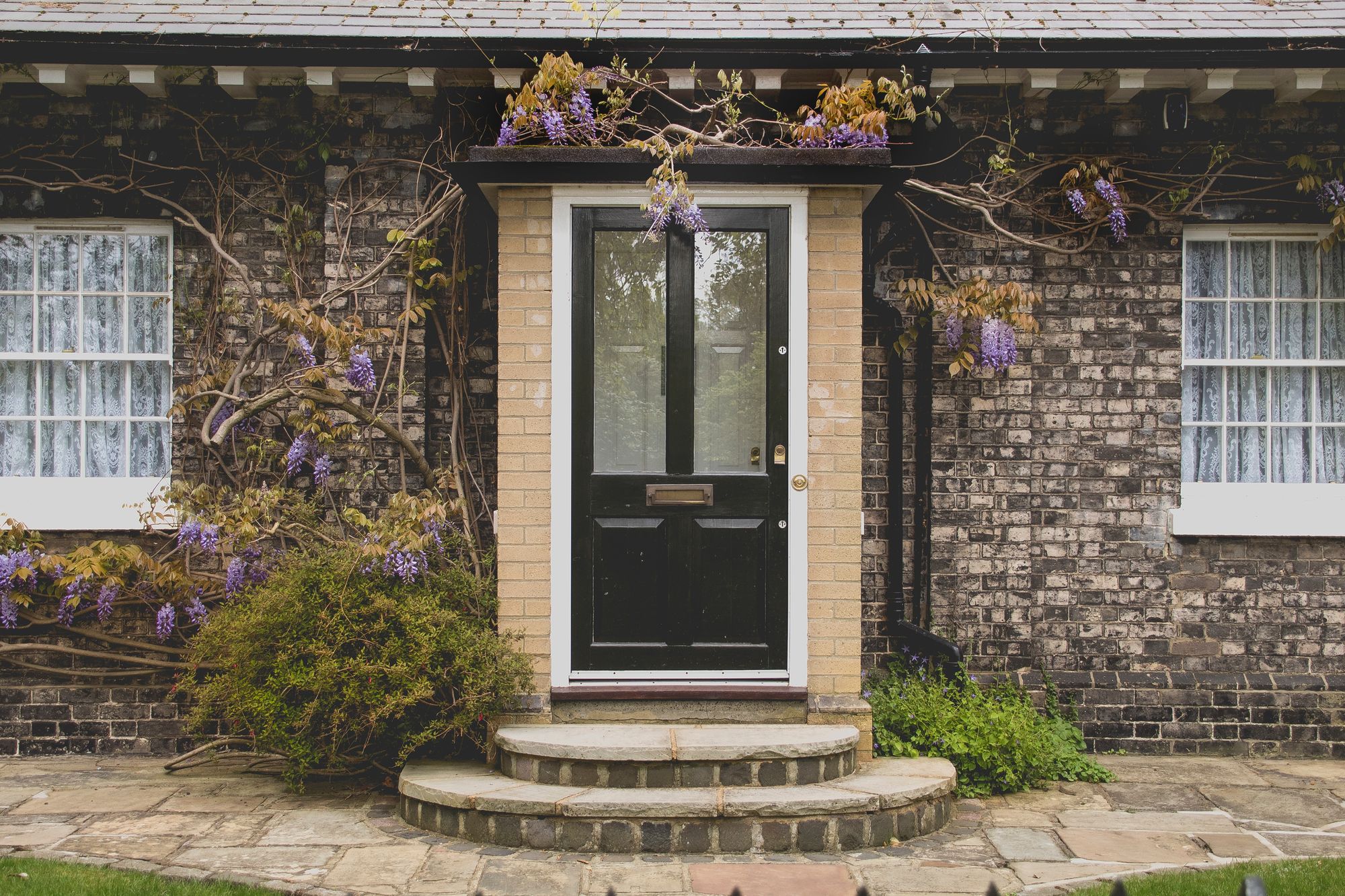 fachada de casa pequeña de piedra con flores