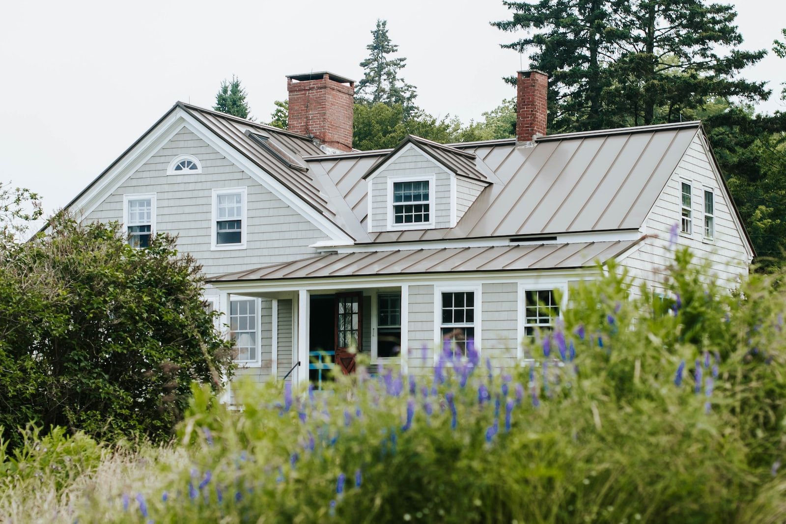 casa de campo sostenible con porche y ventanas blancas
