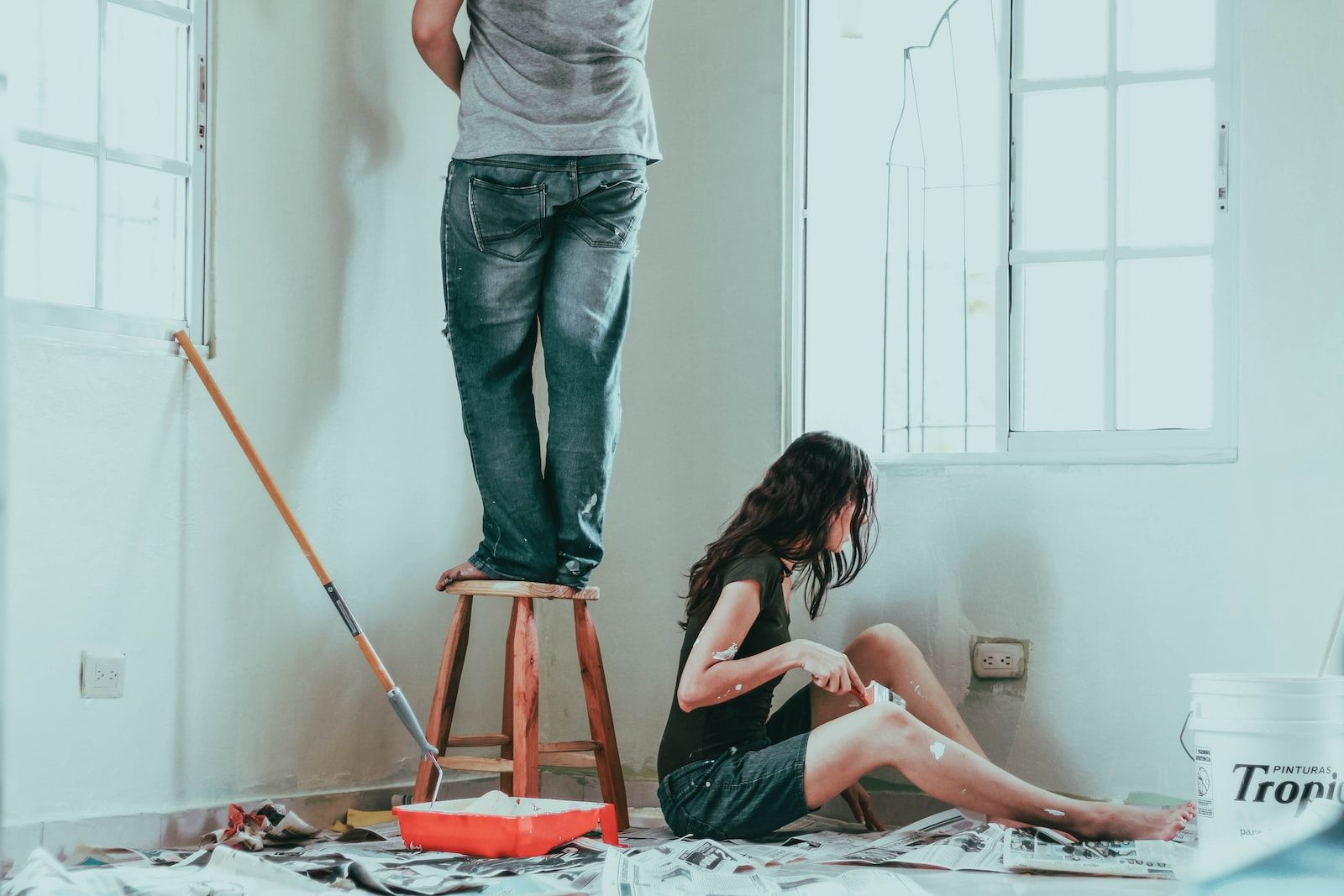 un homme et une femme peintent la mur blanche