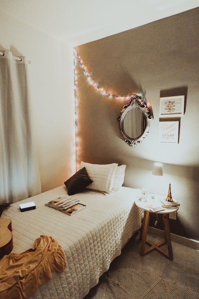 lit dans une chambre universitaire aven un lit simple et un miroir au-dessus