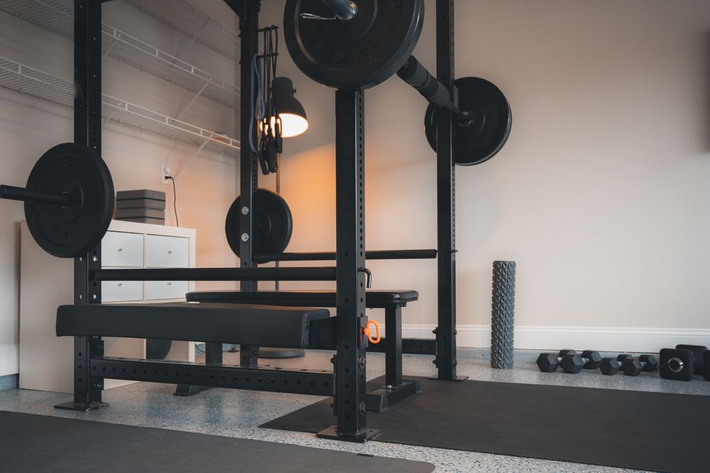 Garage gym with weight rack, bench, dumbbells and resistance bands