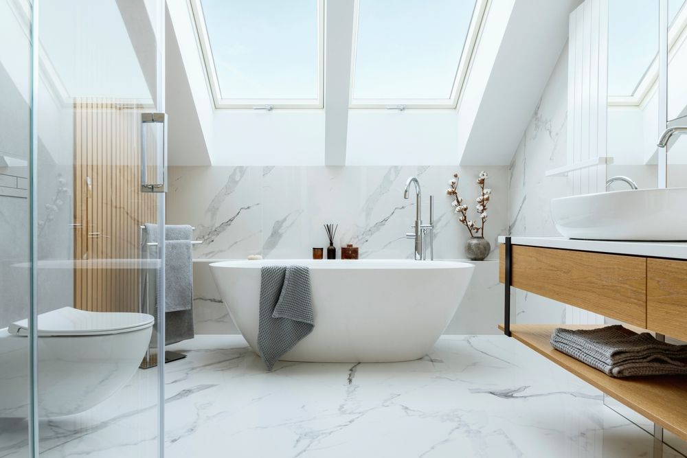 ein minimalistisches Badezimmer mit einer weißen Badewanne und gemusterten Marmorfliesen