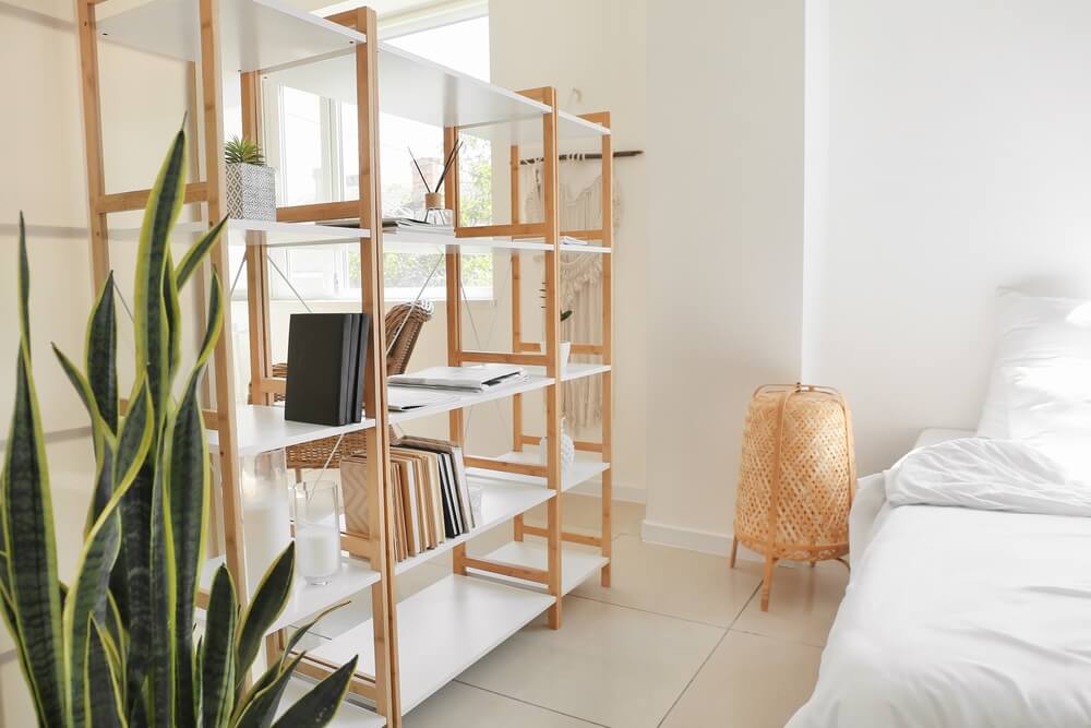 Wooden book shelves in interior of light bedroom