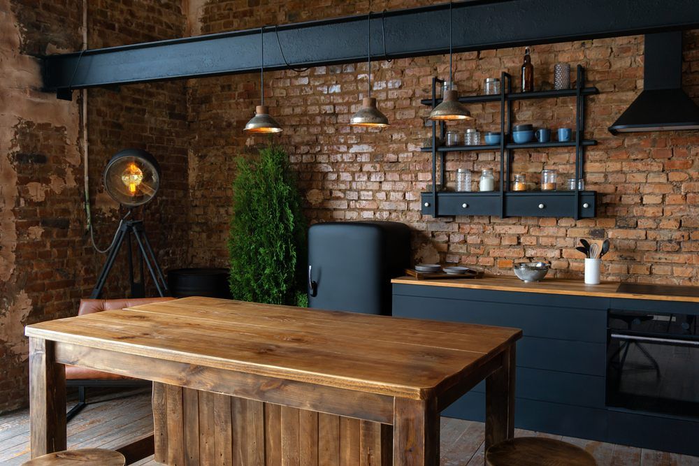 маленькая кухня в стиле лофт с кирпичными стенами и деревянным столом