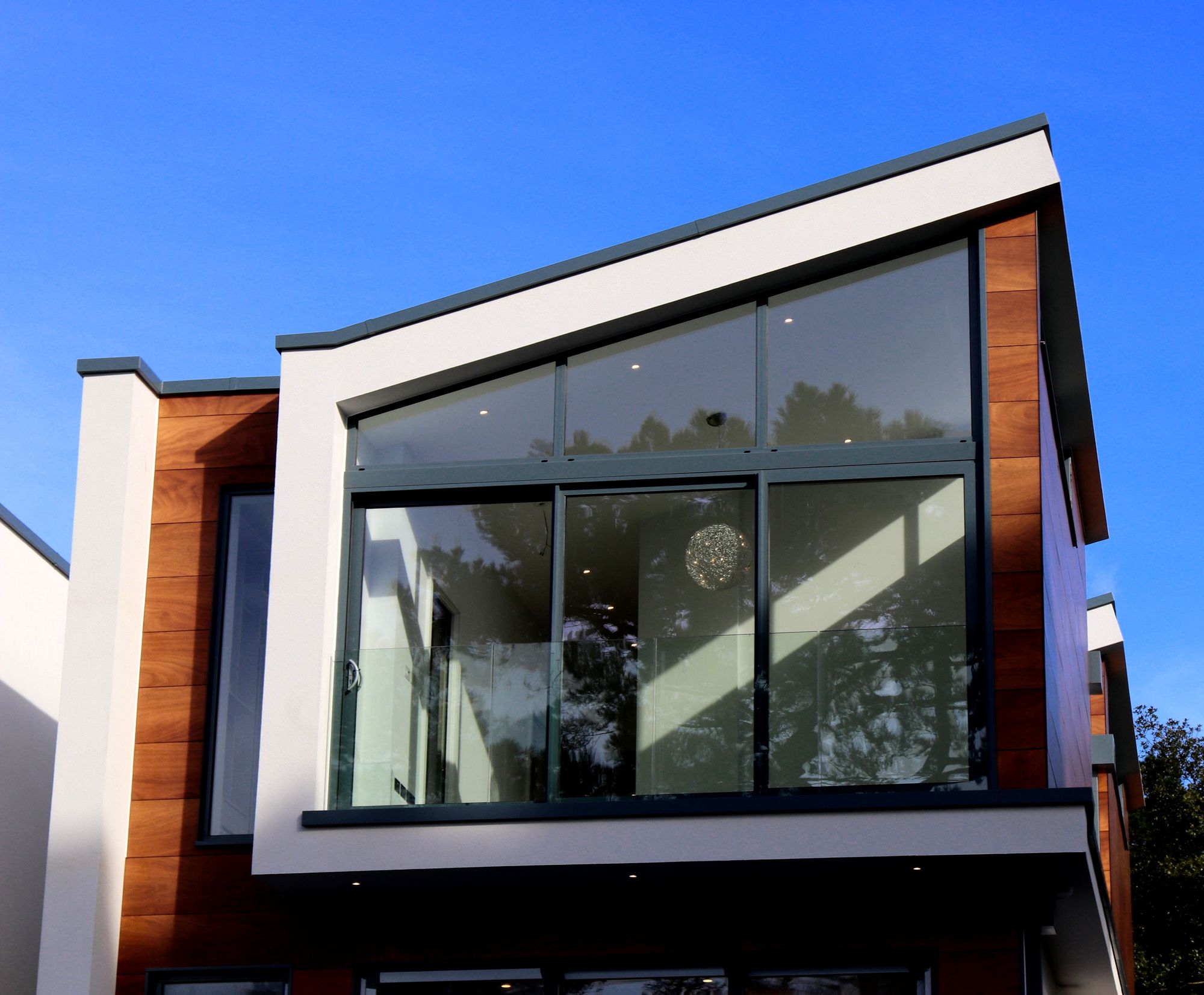Uma pequena casa com janelas de vidro e telhado embutido, dando um toque contemporâneo à estrutura