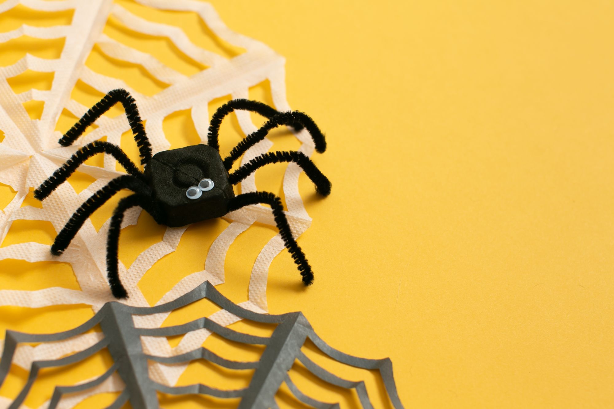 schwarze spinne dekor für halloween gegen gelben hintergrund