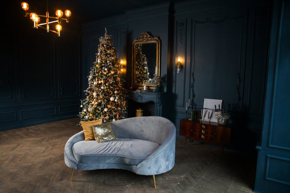 Holiday decorated room with fireplace,light blue sofa, and golden pillows