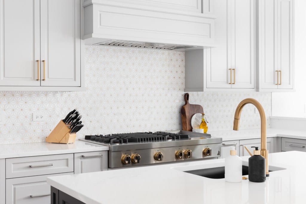 Luxurous kitchen with white an gold tiled backsplash