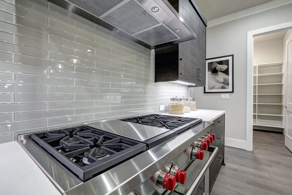 Modern gray kitchen with a glossy gray tile backsplash. 