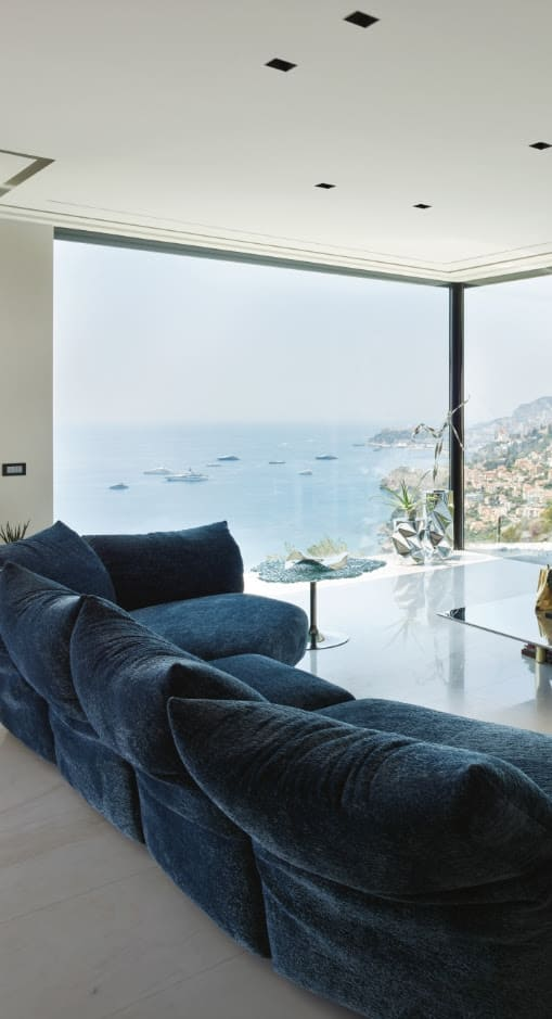 modern living room with blue designer sofa by edra
