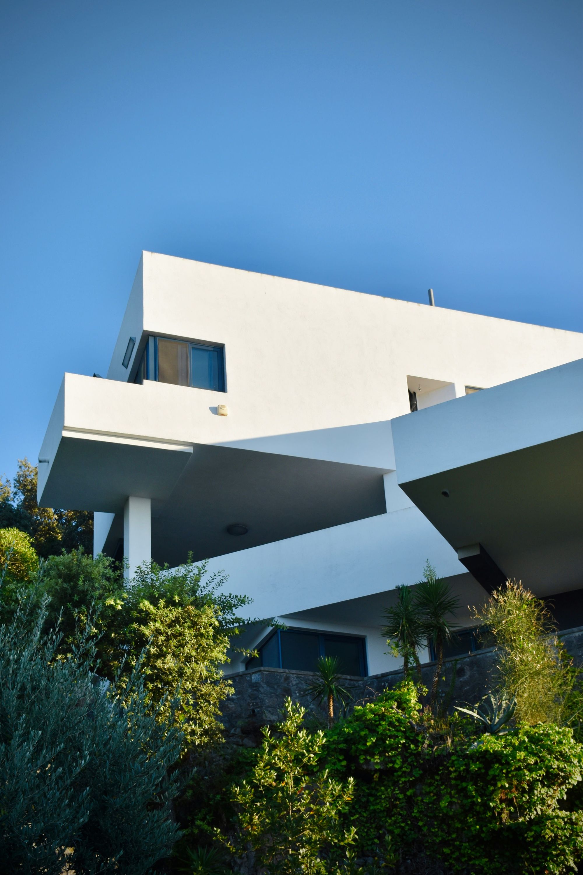 casa moderna brutalista en el campo con paredes blancas y terrazas