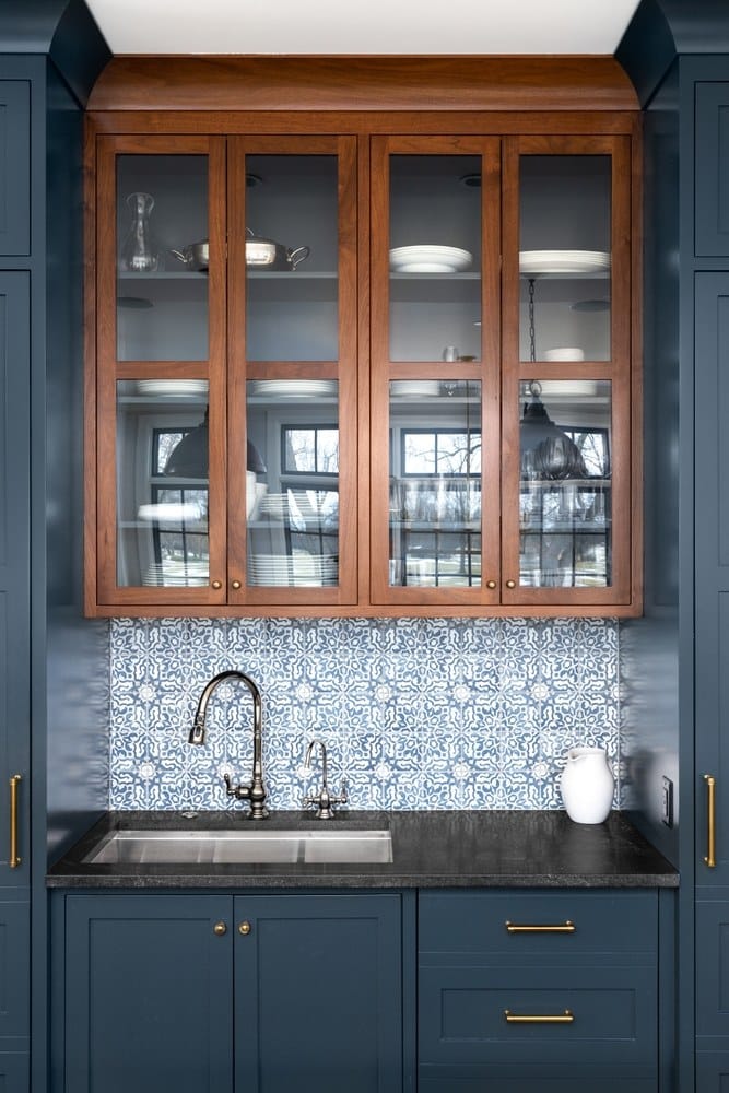 A kitchen sink with a beautiful pattern tiled backsplash 